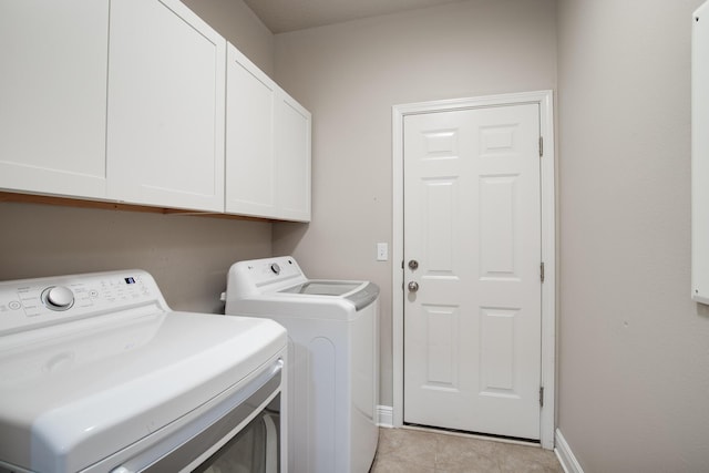 washroom with washer and dryer, cabinet space, baseboards, and light tile patterned floors