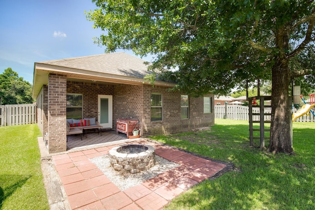 rear view of house featuring a lawn, a patio, fence private yard, a playground, and brick siding