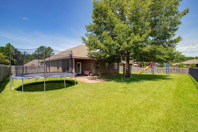 view of yard with a trampoline, a patio area, a playground, and a fenced backyard