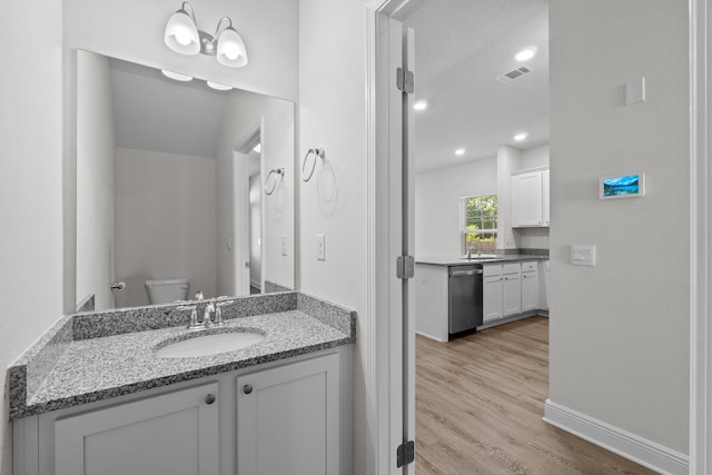 bathroom featuring visible vents, vanity, toilet, and wood finished floors