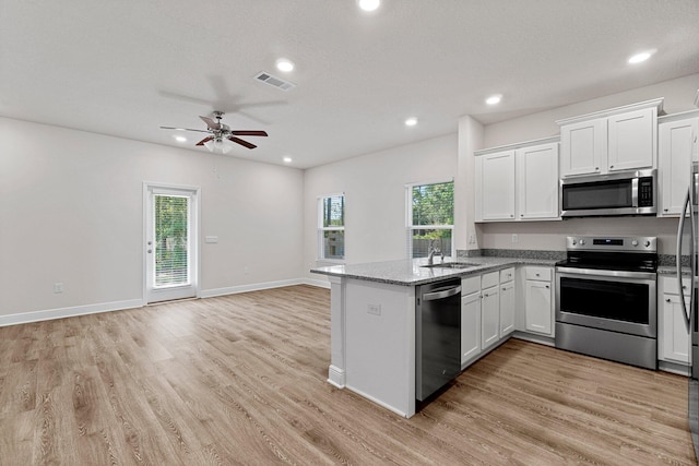 kitchen with light wood finished floors, visible vents, appliances with stainless steel finishes, and a sink