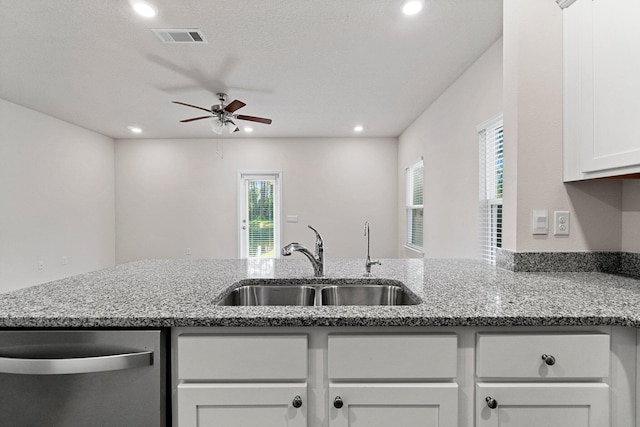 kitchen with recessed lighting, visible vents, stainless steel dishwasher, stone countertops, and a sink