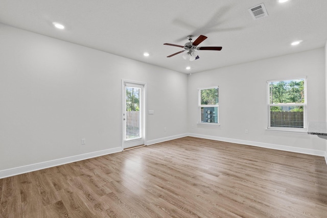 empty room with baseboards, wood finished floors, and a healthy amount of sunlight