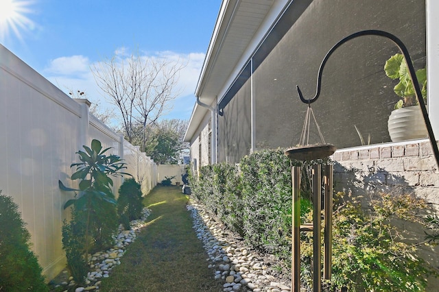 view of side of home featuring fence and stucco siding