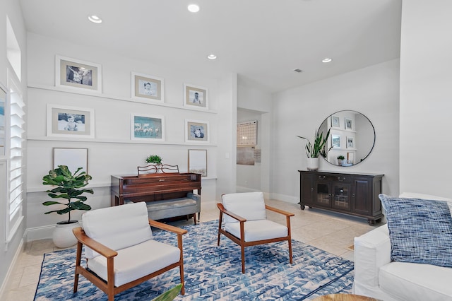 living room featuring baseboards, light tile patterned flooring, and recessed lighting