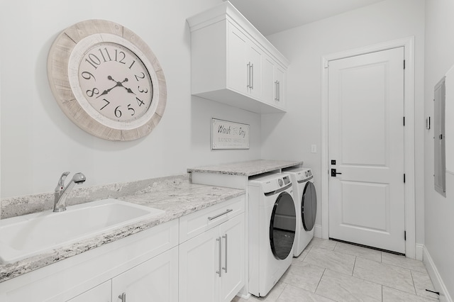 laundry area featuring cabinet space, baseboards, a sink, and washing machine and clothes dryer