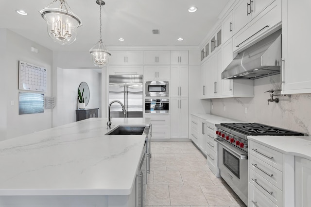 kitchen with built in appliances, recessed lighting, a sink, white cabinets, and backsplash