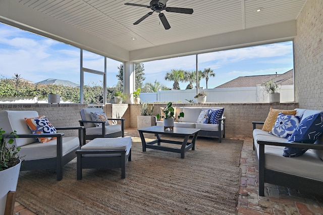 sunroom / solarium featuring a ceiling fan and a mountain view