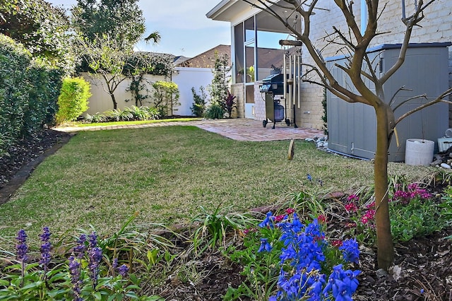 view of yard with a patio, a fenced backyard, and a sunroom