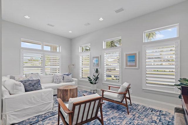 living area featuring recessed lighting, visible vents, and baseboards