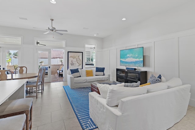 living area with light tile patterned floors, recessed lighting, a ceiling fan, and a decorative wall