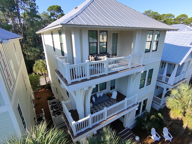 rear view of property featuring a standing seam roof and metal roof