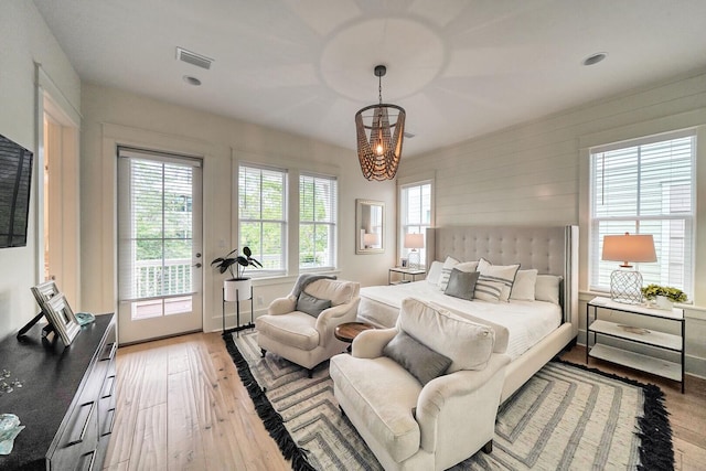 bedroom with access to exterior, visible vents, and hardwood / wood-style flooring