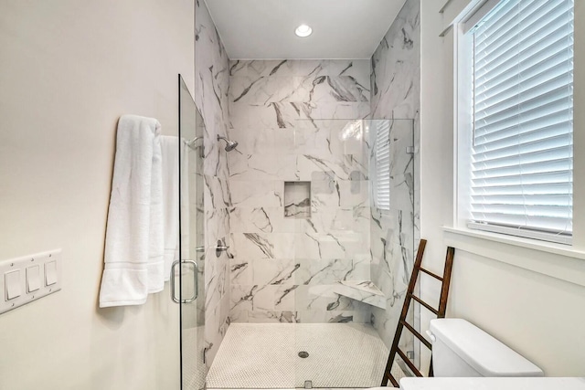 bathroom featuring toilet, a marble finish shower, and recessed lighting