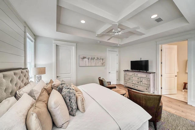 bedroom featuring coffered ceiling, visible vents, a ceiling fan, light wood finished floors, and beamed ceiling