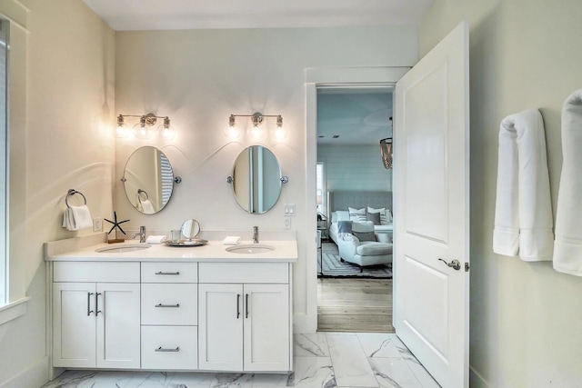 ensuite bathroom featuring marble finish floor, double vanity, ensuite bath, and a sink