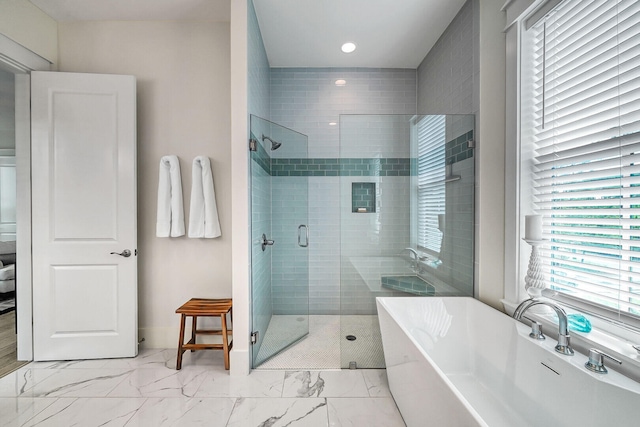 full bath with marble finish floor, a stall shower, and a soaking tub