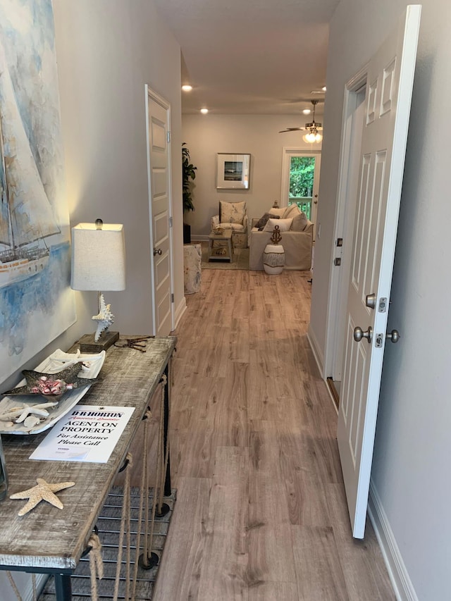 hallway with baseboards and wood finished floors