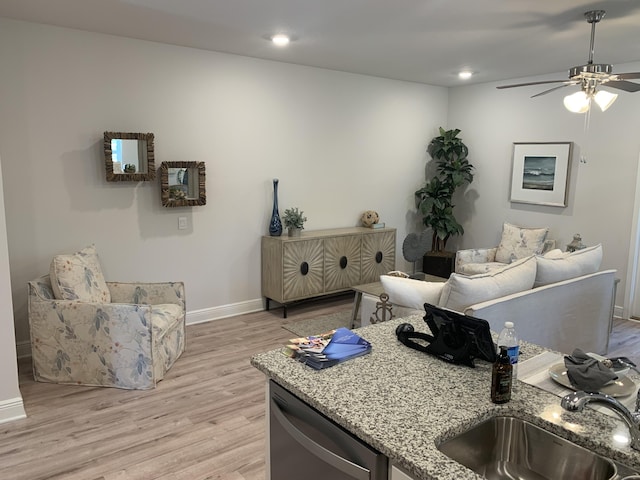 living area with light wood-type flooring, ceiling fan, baseboards, and recessed lighting