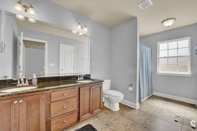 full bathroom featuring toilet, double vanity, visible vents, and a sink