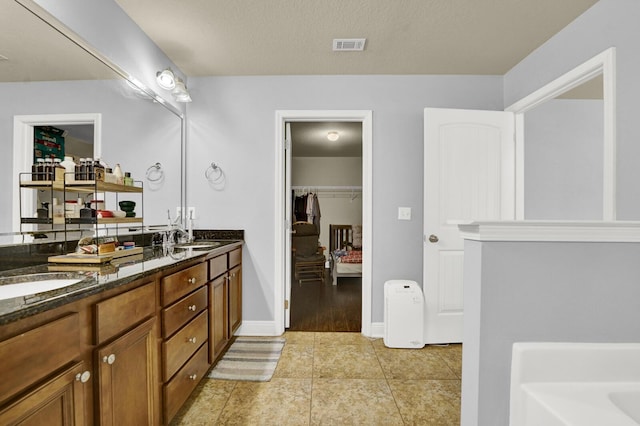 full bath featuring double vanity, visible vents, a sink, and tile patterned floors