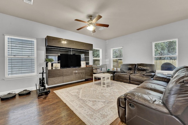 living room with visible vents, ceiling fan, baseboards, and wood finished floors