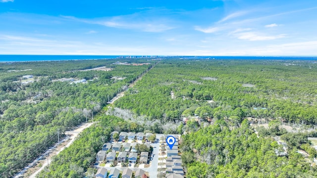 birds eye view of property featuring a water view and a wooded view