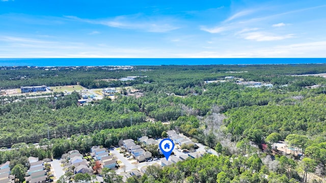 birds eye view of property featuring a water view and a wooded view