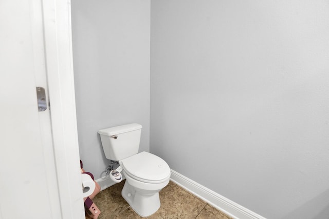 bathroom featuring tile patterned flooring, toilet, and baseboards