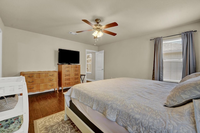 bedroom with dark wood-type flooring, visible vents, and a ceiling fan