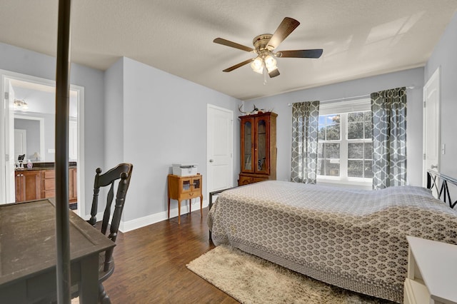 bedroom with a textured ceiling, dark wood-style flooring, a ceiling fan, and baseboards