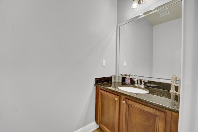 bathroom featuring visible vents, vanity, and baseboards