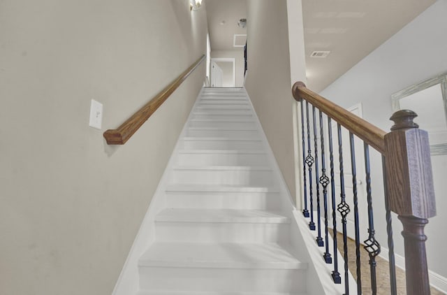 stairway with visible vents and baseboards