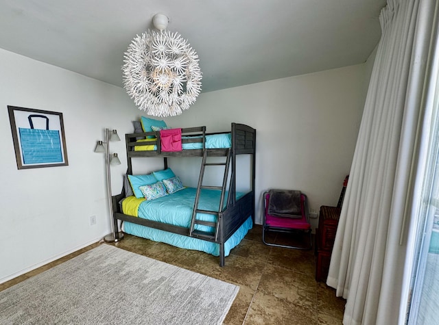 bedroom featuring baseboards and an inviting chandelier