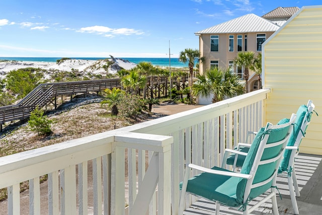 balcony featuring a beach view and a water view