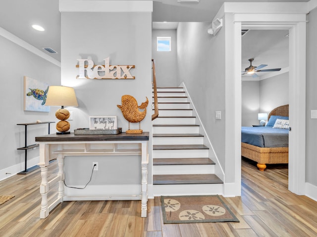 staircase featuring recessed lighting, wood finished floors, a ceiling fan, baseboards, and crown molding