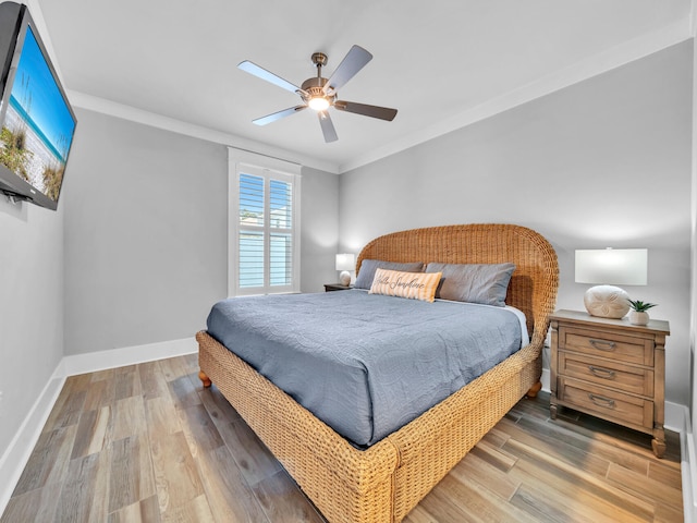 bedroom featuring ceiling fan, baseboards, wood finished floors, and ornamental molding