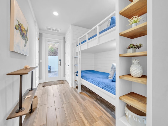 bedroom with wood finish floors, recessed lighting, visible vents, and access to exterior