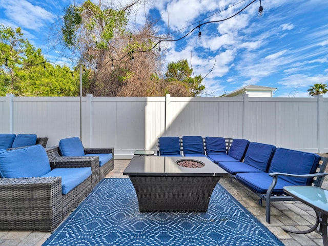 view of patio / terrace with a fenced backyard and an outdoor living space with a fire pit