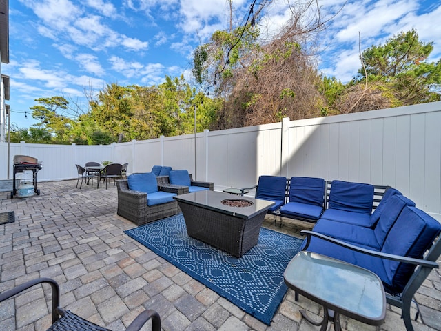 view of patio / terrace featuring a fenced backyard, outdoor dining area, area for grilling, and an outdoor living space with a fire pit