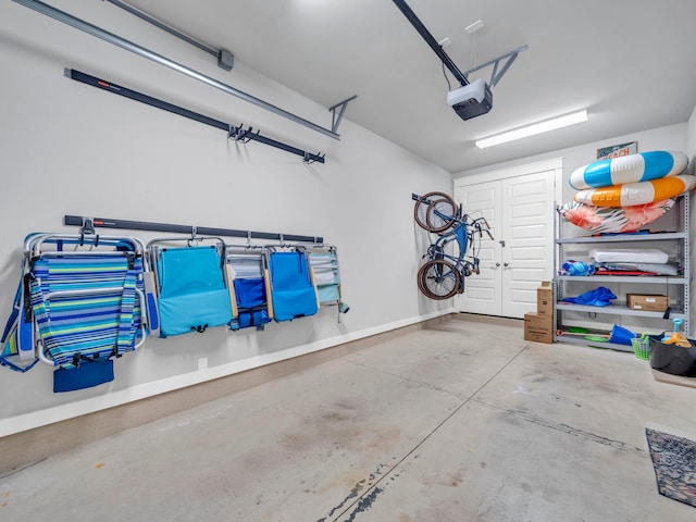 garage with a garage door opener and baseboards