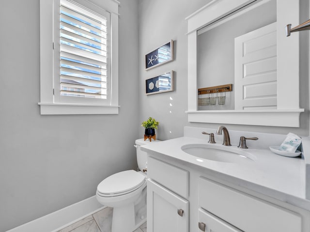 bathroom with marble finish floor, vanity, toilet, and baseboards