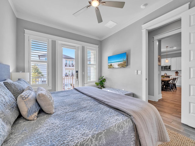 bedroom featuring light wood-style floors, access to outside, multiple windows, and ornamental molding