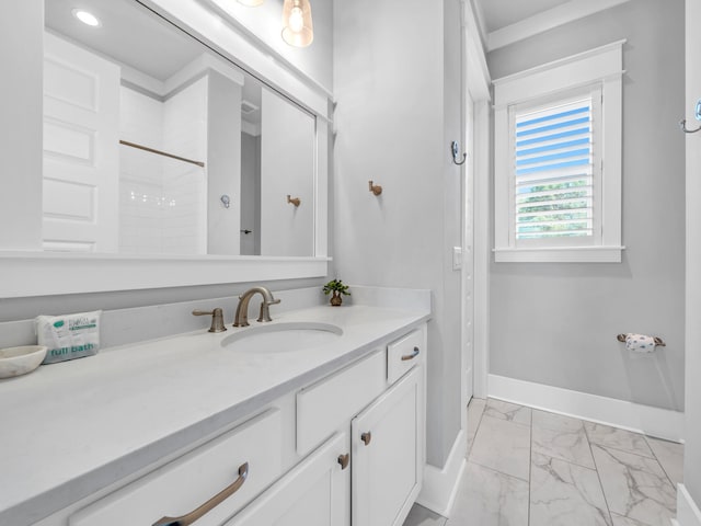 full bathroom featuring marble finish floor, walk in shower, vanity, and baseboards