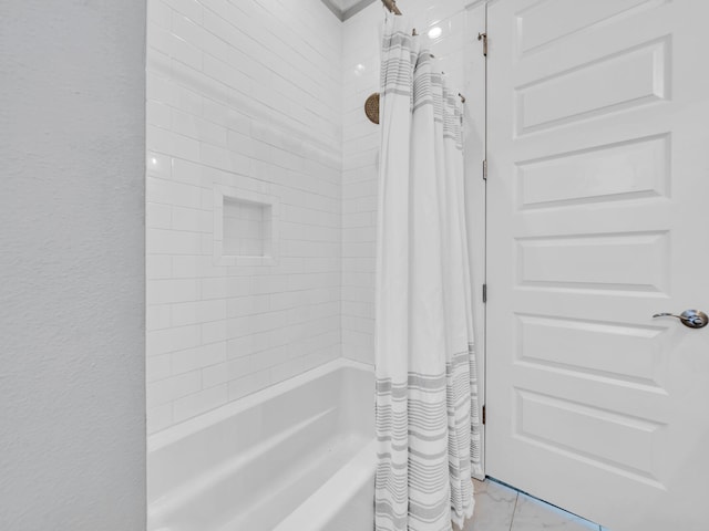 bathroom featuring shower / bath combo and a textured wall