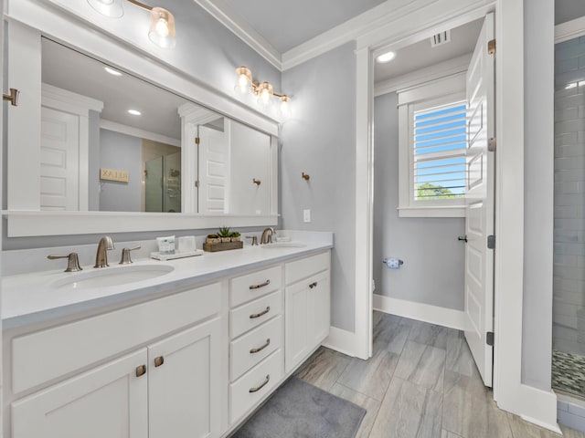 bathroom with double vanity, a shower stall, visible vents, and a sink