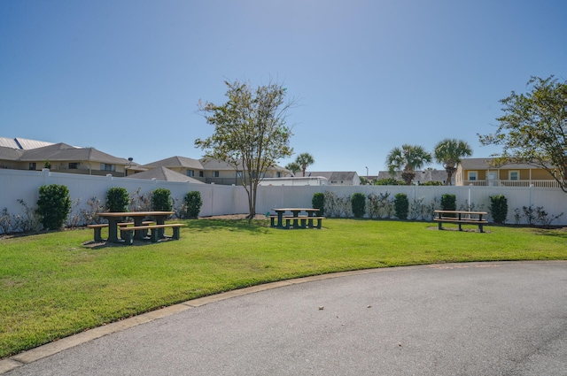 view of community featuring a fenced backyard and a lawn