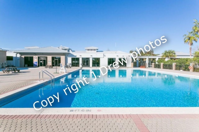 community pool featuring fence and a patio