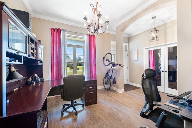 home office with a chandelier, french doors, ornamental molding, and light wood-style flooring