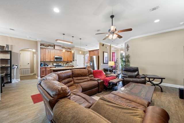 living room featuring visible vents, arched walkways, and ornamental molding